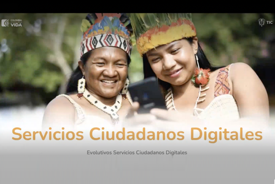 Imagen de dos mujeres indígenas sonrientes mirando un teléfono celular.